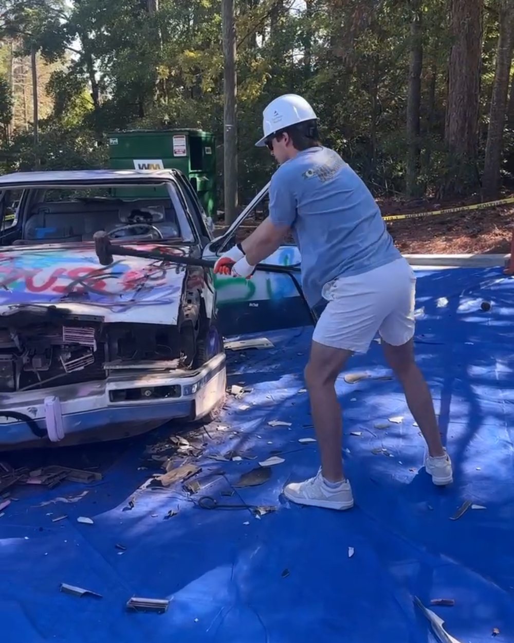 A brother swings a sledgehammer at the graffiti-covered Taxi Bash car